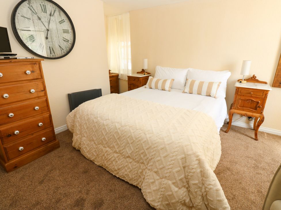 A bedroom with a bed and dresser at Arch Mews Cottage Middleton-In-Teesdale