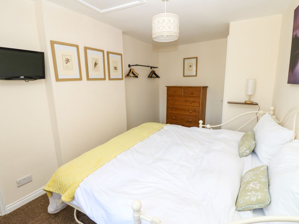 A bedroom with a bed and television at Arch Mews Cottage Middleton-In-Teesdale