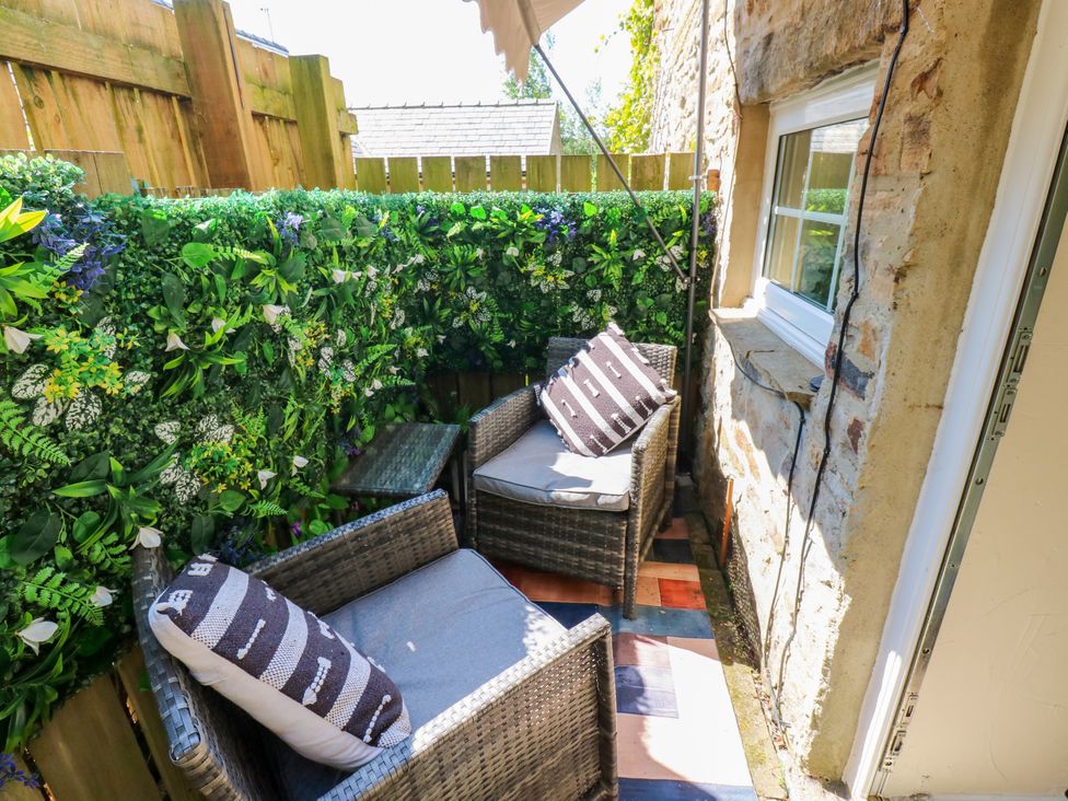 A garden area with chairs and greenery at Arch Mews Cottage Middleton-In-Teesdale