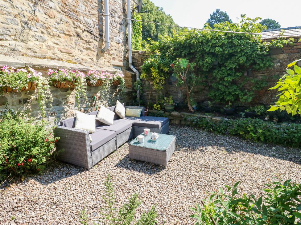 A garden with seating and flower pots at Arch Mews Cottage Middleton-In-Teesdale