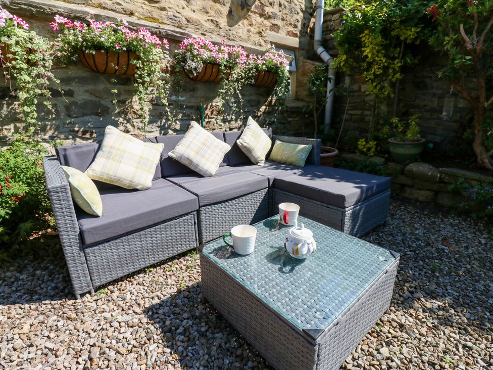 An outdoor seating area with a sofa and coffee table at Arch Mews Cottage Middleton-In-Teesdale