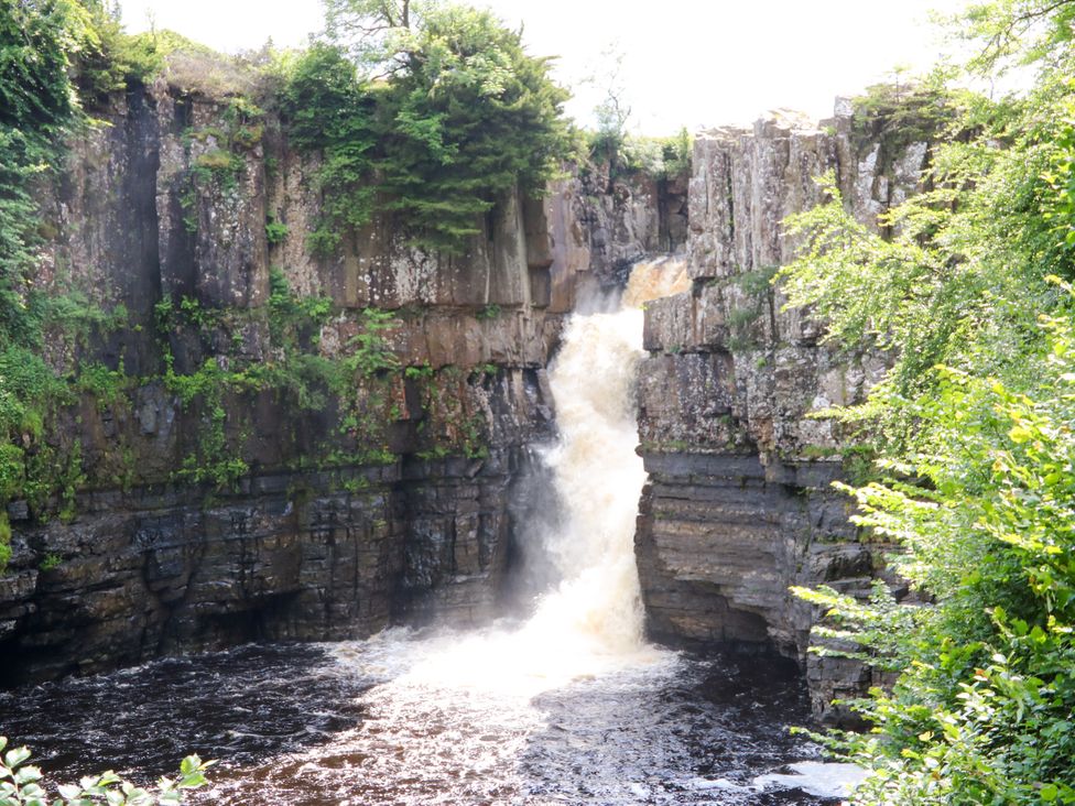 A waterfall cascading over rocks in a natural setting at Arch Mews Cottage Middleton-In-Teesdale