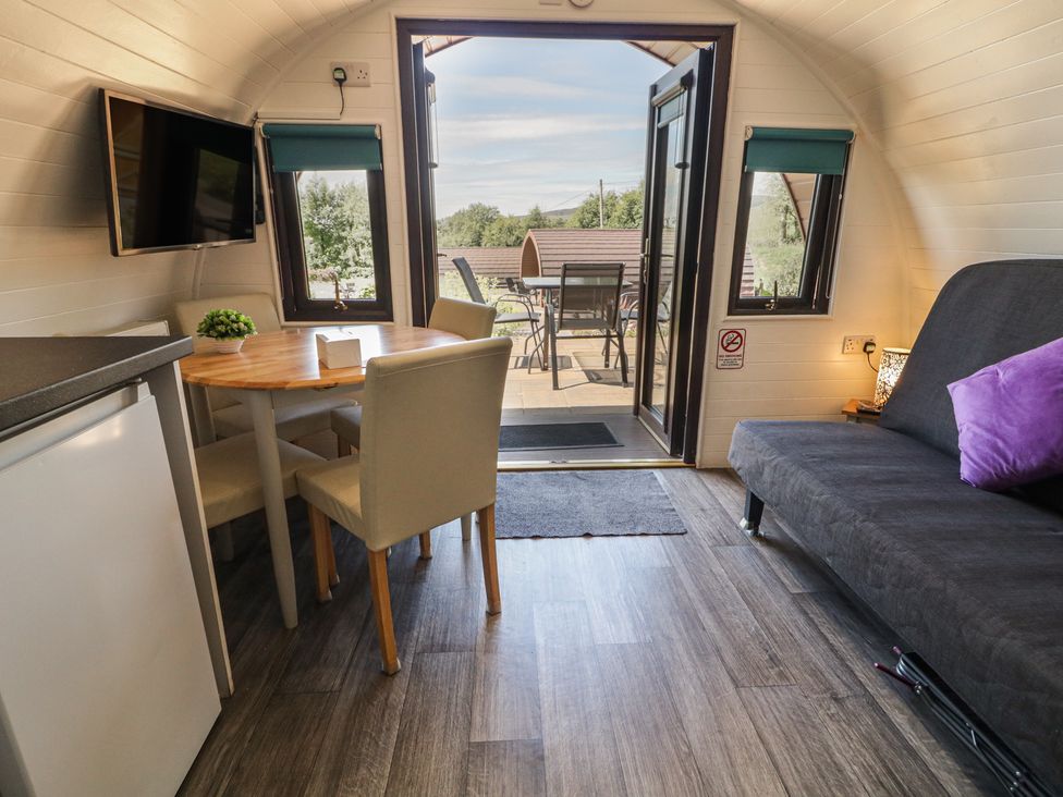 A living room with a table and chairs at Gortin Glen Glamping Pod 1 