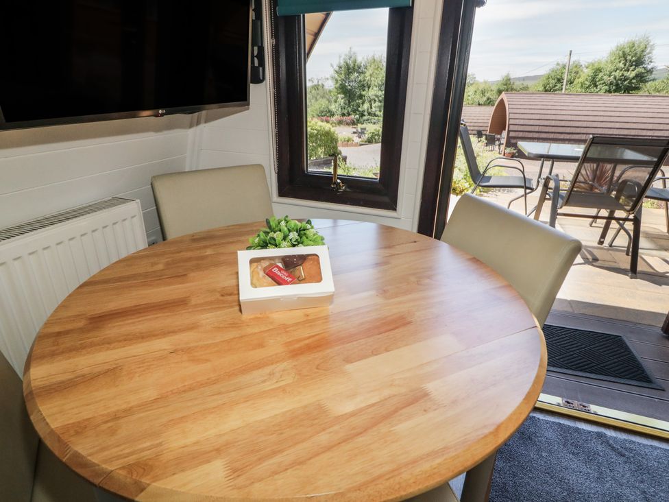 A dining room with a table and chairs at Gortin Glen Glamping Pod 1