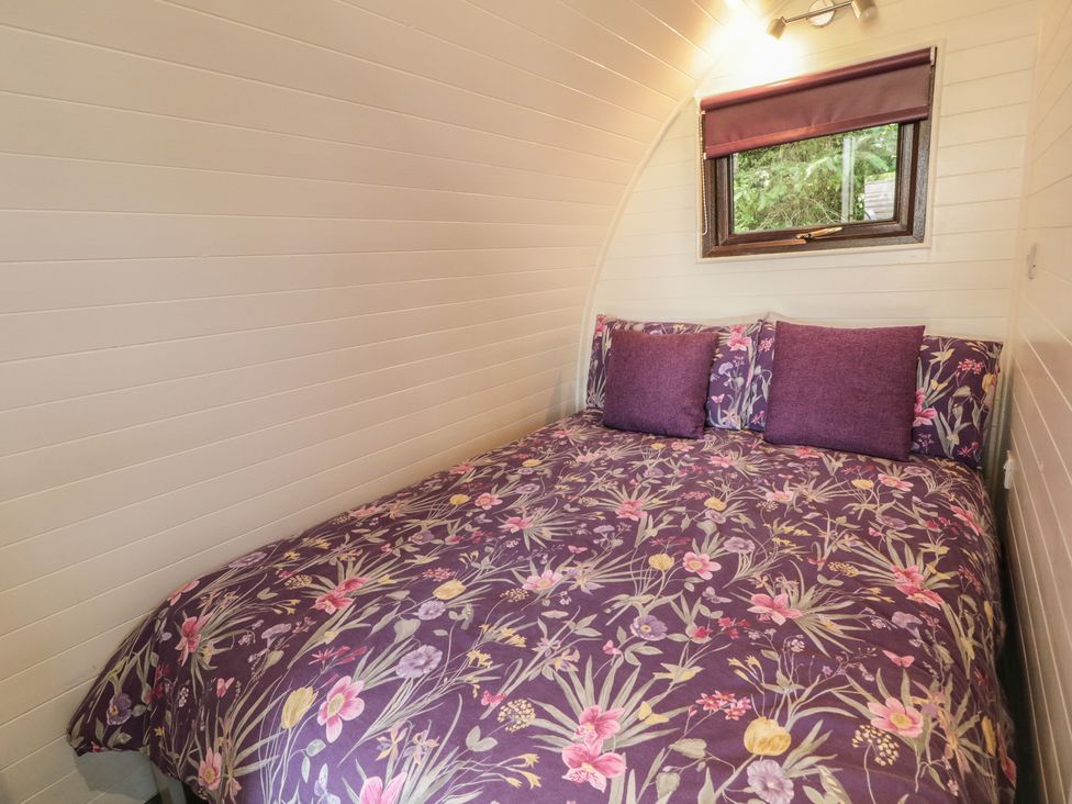 A bedroom with a bed and window at Gortin Glen Glamping Pod 1