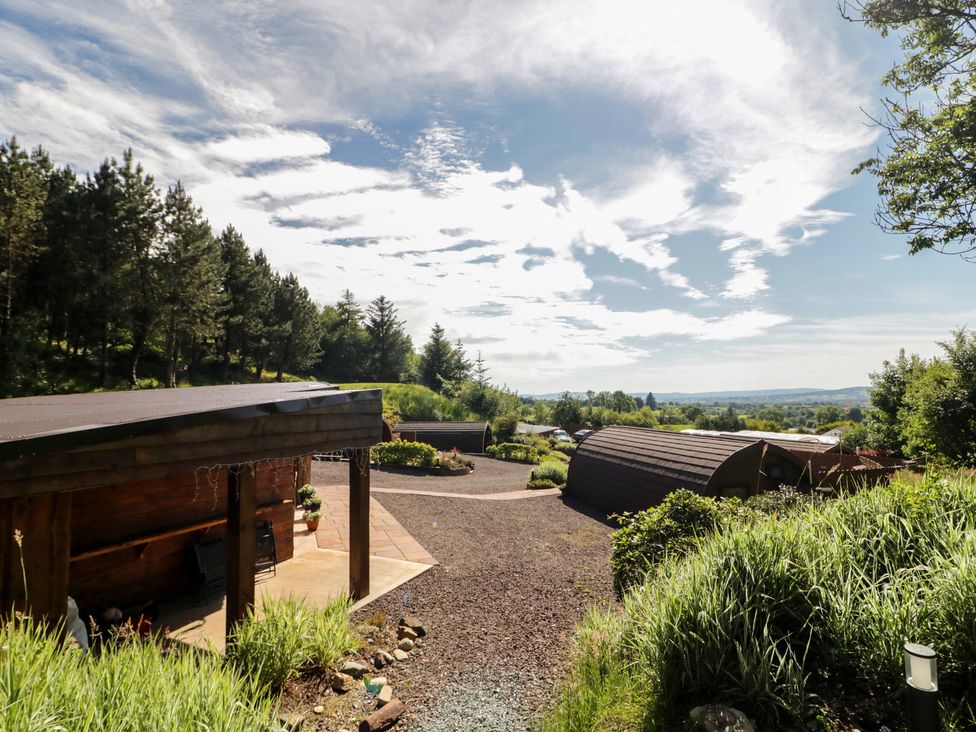 An outdoor view with cabins and a pathway at Gortin Glen Glamping Pod 1