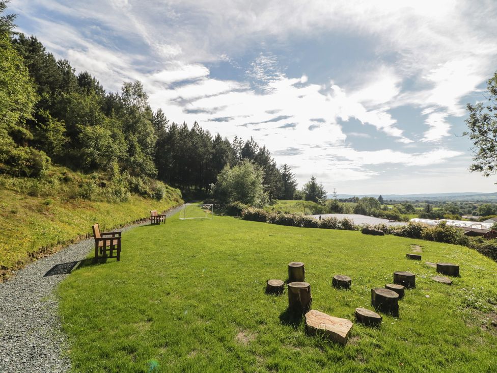 A garden with seating and wooden stumps at Gortin Glen Glamping Pod 1