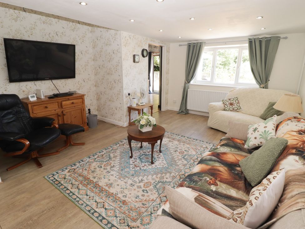 A living room with a sofa and television at Farm Cottage