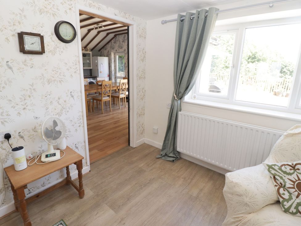 A living room with a fan and clock at Farm Cottage
