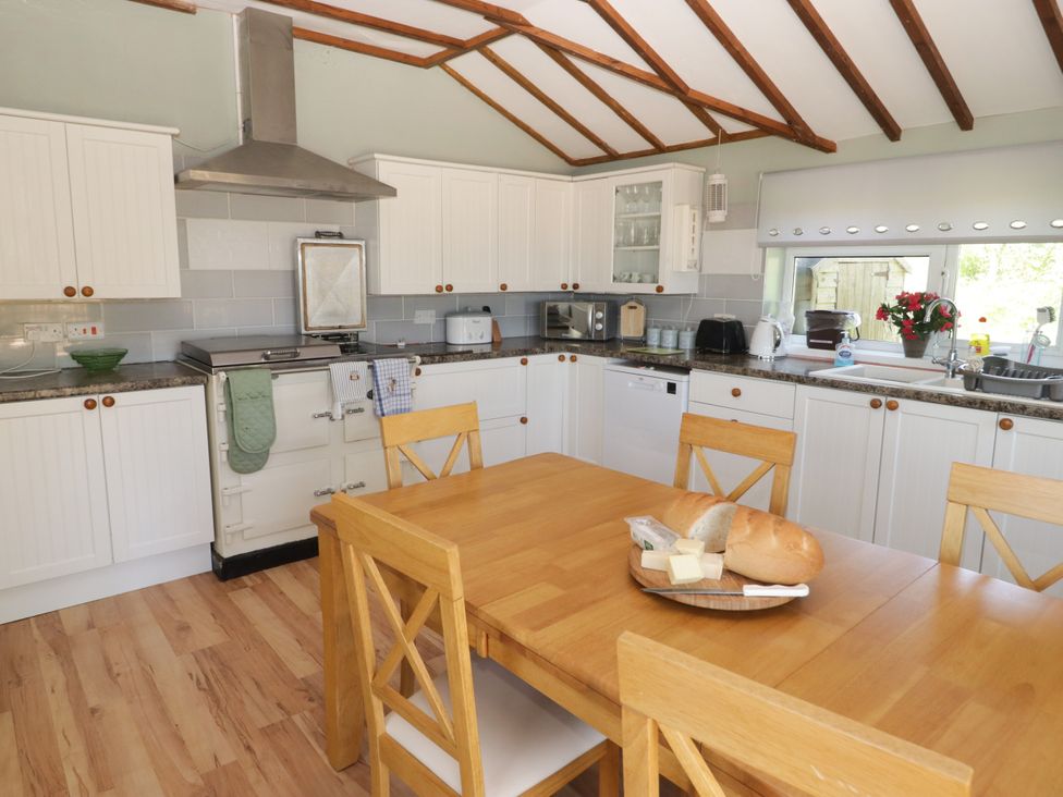 A kitchen with a wooden table and chairs at Farm Cottage in 