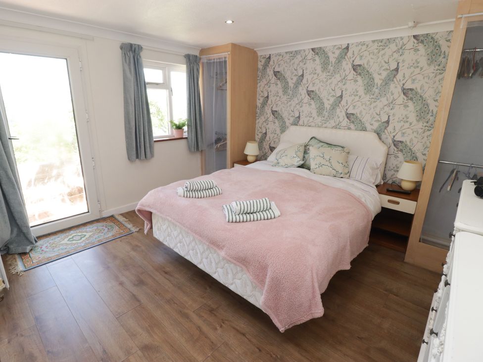A bedroom with a double bed and a wardrobe at Farm Cottage