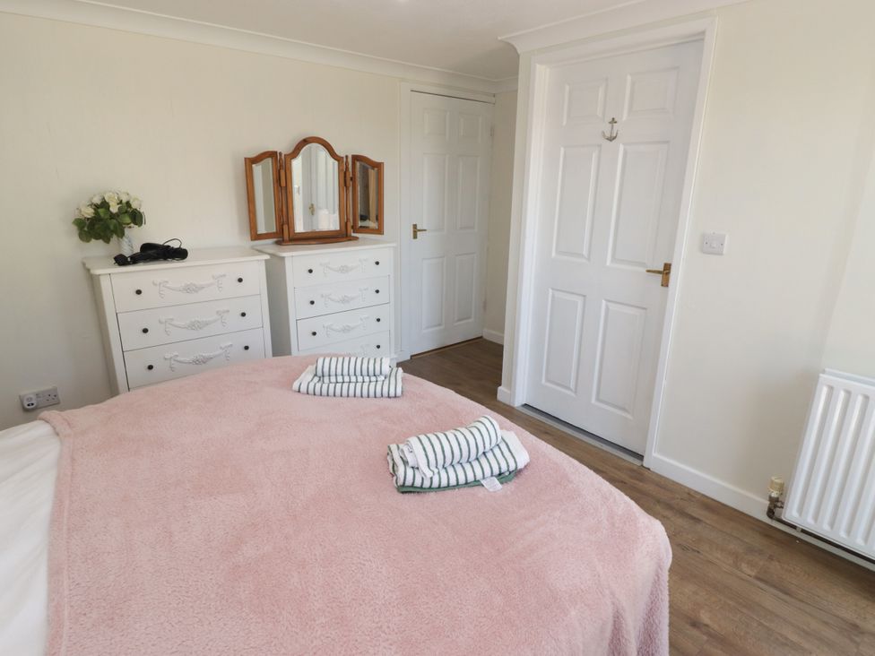A bedroom with a bed and dresser at Farm Cottage