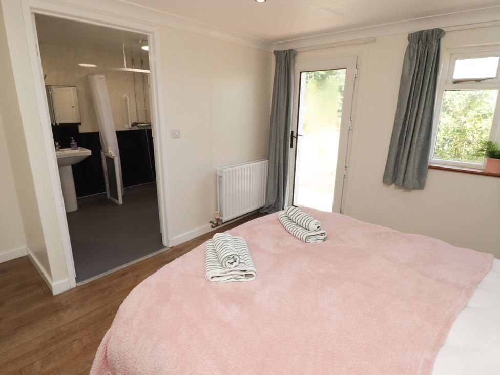 A bedroom with a bed and towels at Farm Cottage