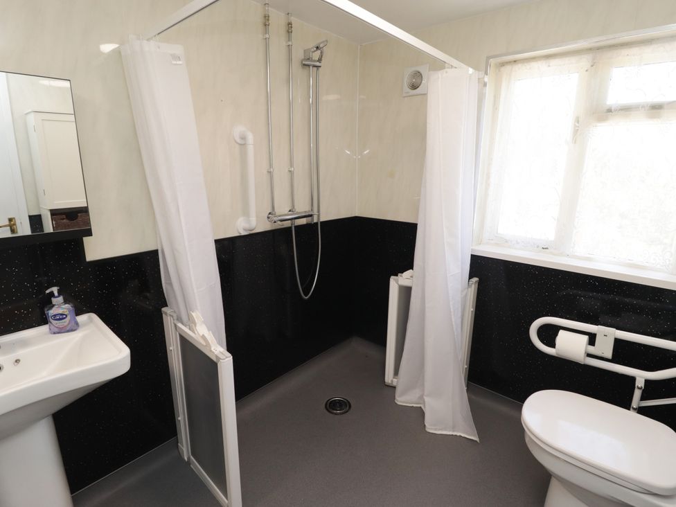 A bathroom with a shower, sink, and toilet at Farm Cottage