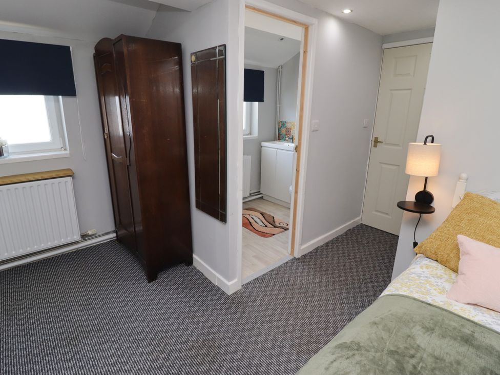 A bedroom with a bed, wardrobe, and lamp at Farm Cottage