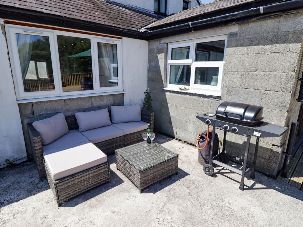An outdoor patio with seating and a barbecue grill at Farm Cottage