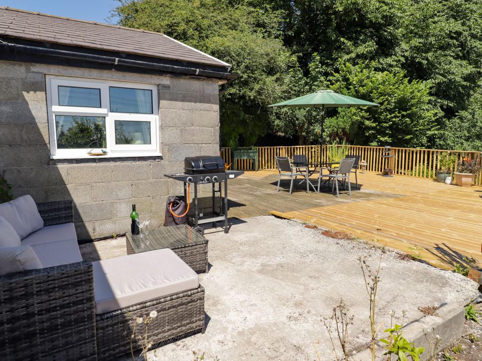 An outdoor seating area with a grill and dining table at Farm Cottage
