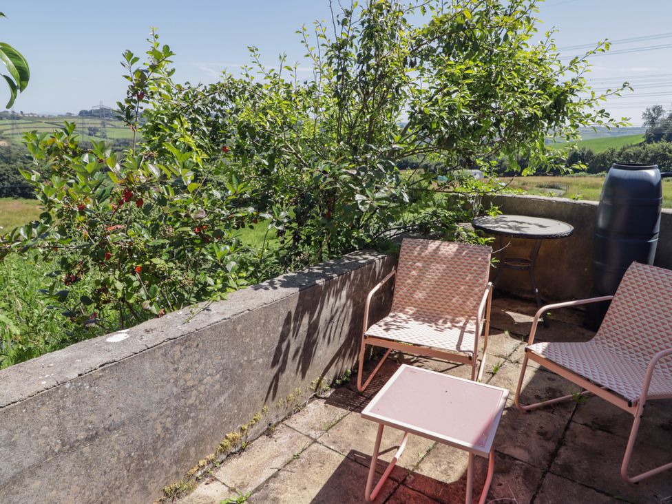 An outdoor seating area with chairs and a table at Farm Cottage
