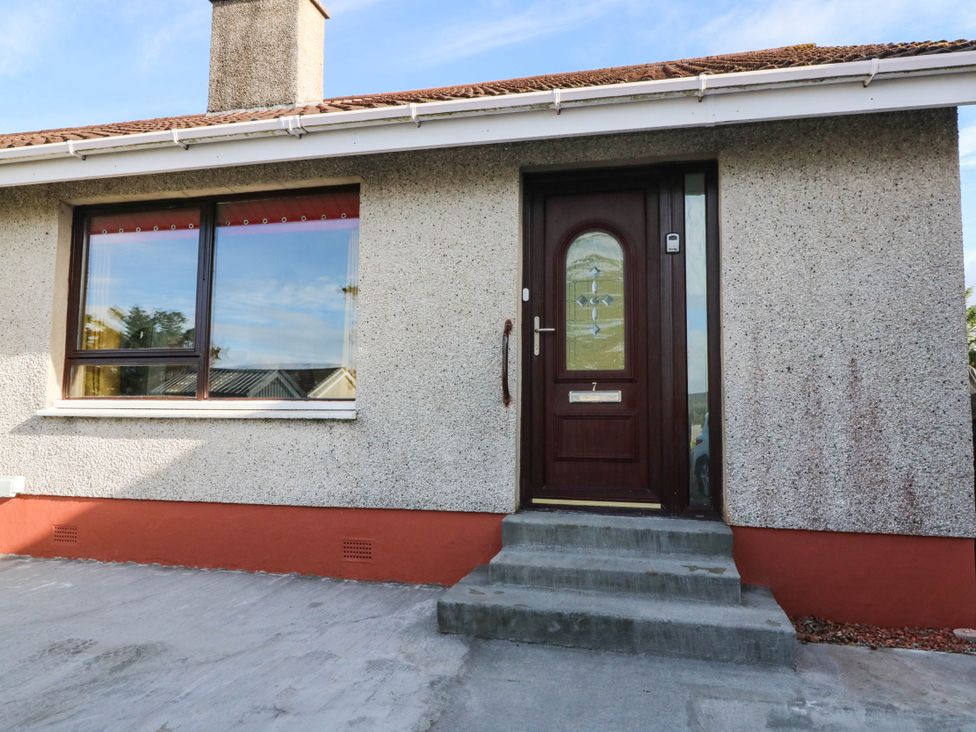 A front entrance with a brown door and window at 7 Creag Ruadh Laxdale near Stornoway