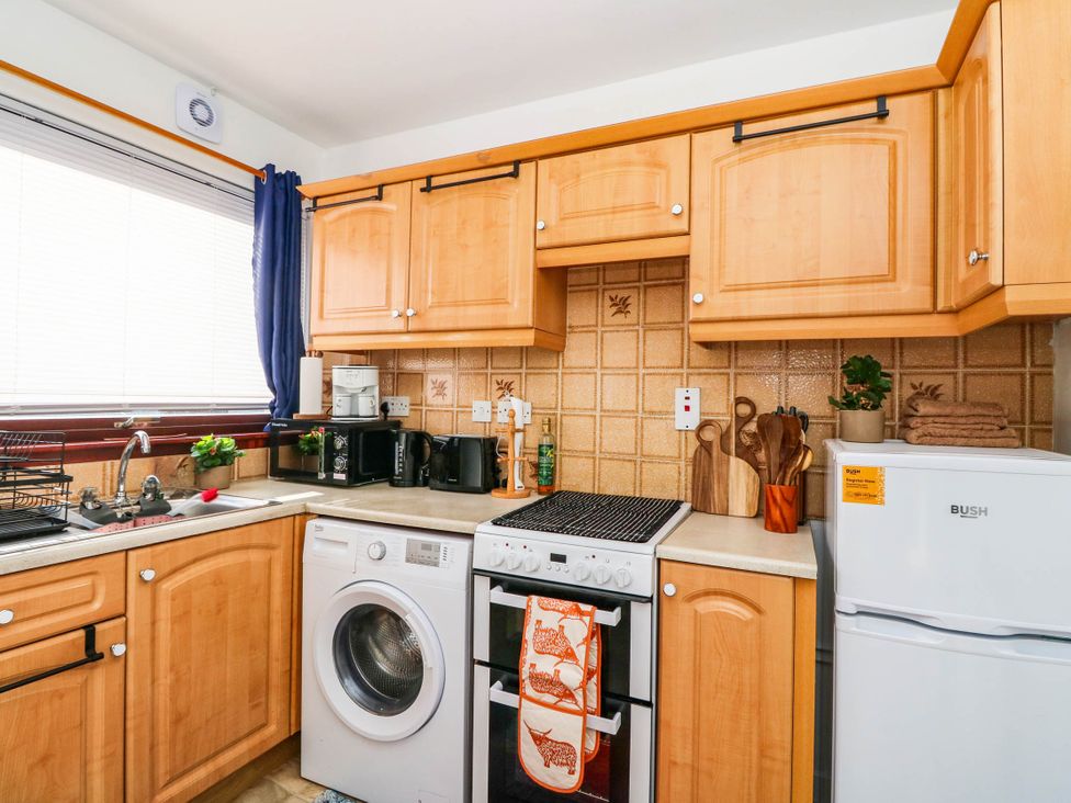 A kitchen with cabinets and appliances at 7 Creag Ruadh in Laxdale near Stornoway