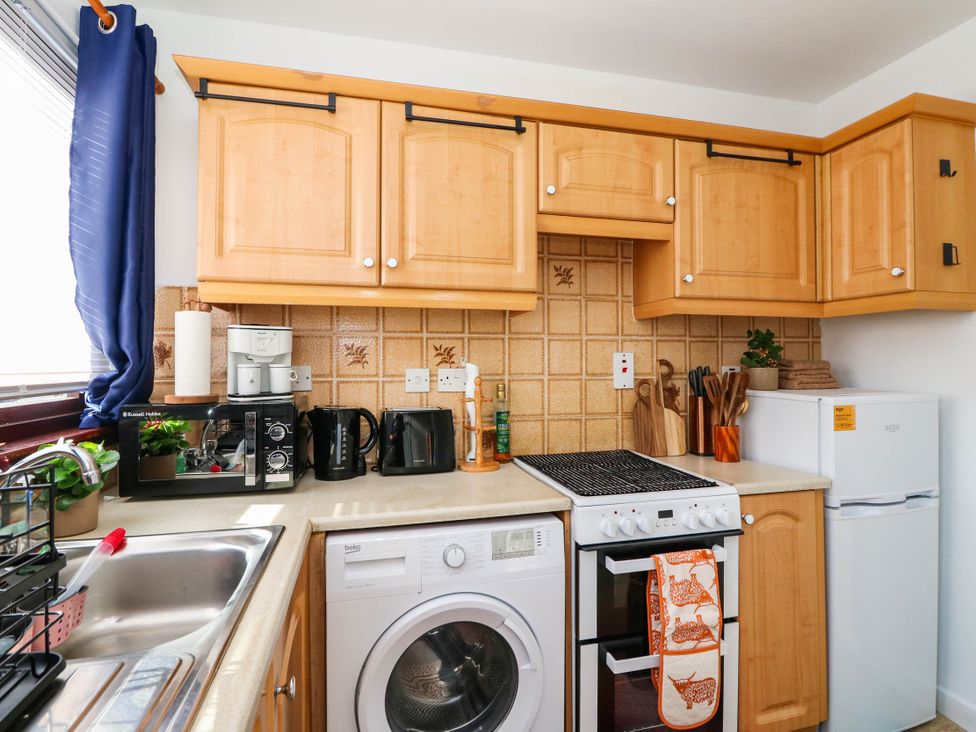 A kitchen with appliances and cabinets at 7 Creag Ruadh in Laxdale near Stornoway