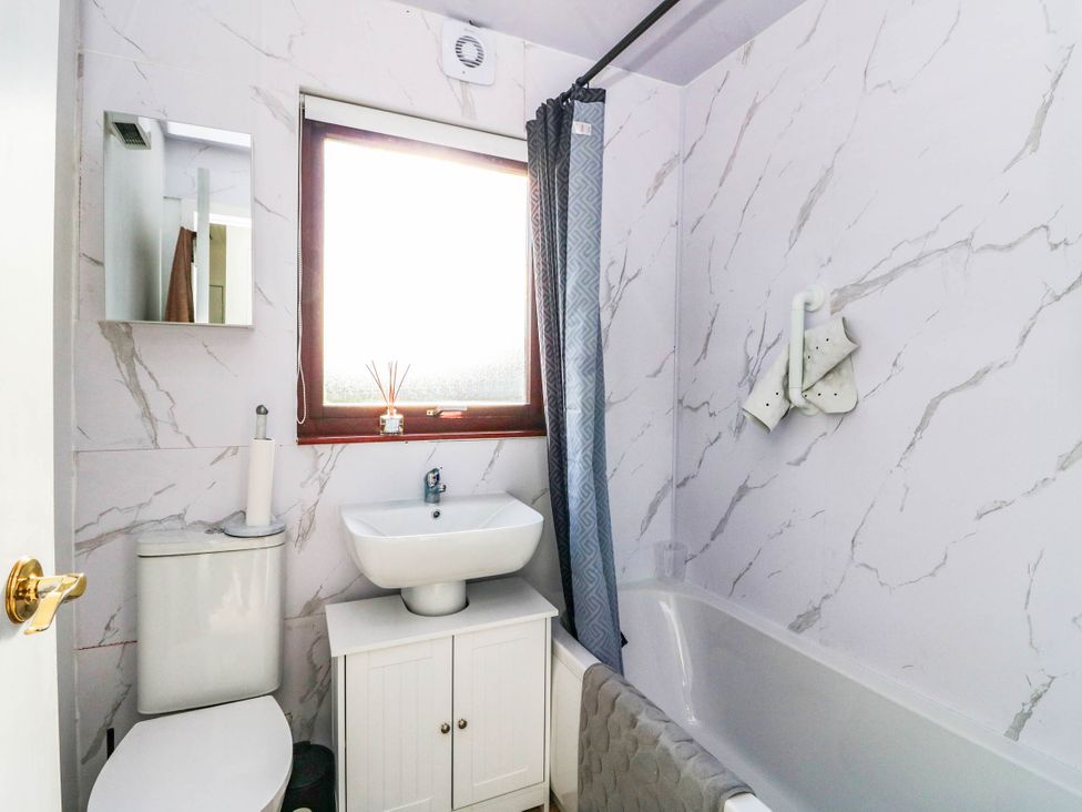 A bathroom with a bathtub, sink and toilet at 7 Creag Ruadh in Laxdale near Stornoway