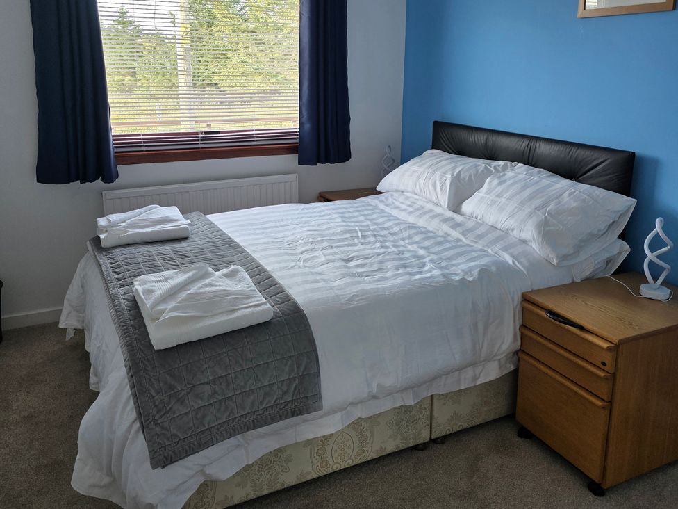 A bedroom with a bed and bedside table at 7 Creag Ruadh in Laxdale near Stornoway