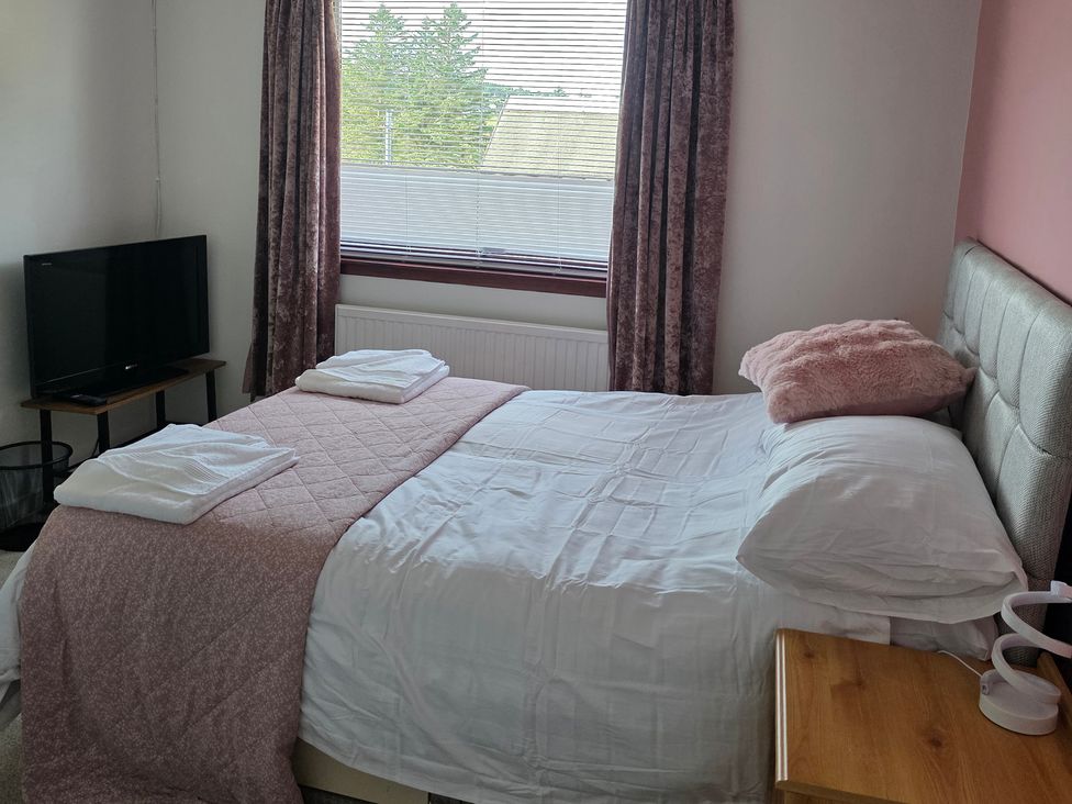 A bedroom with a bed and television at 7 Creag Ruadh near Stornoway