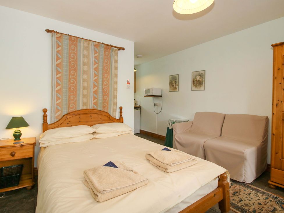 A bedroom with a bed and sofa at Apartment 2 in Lydbury North