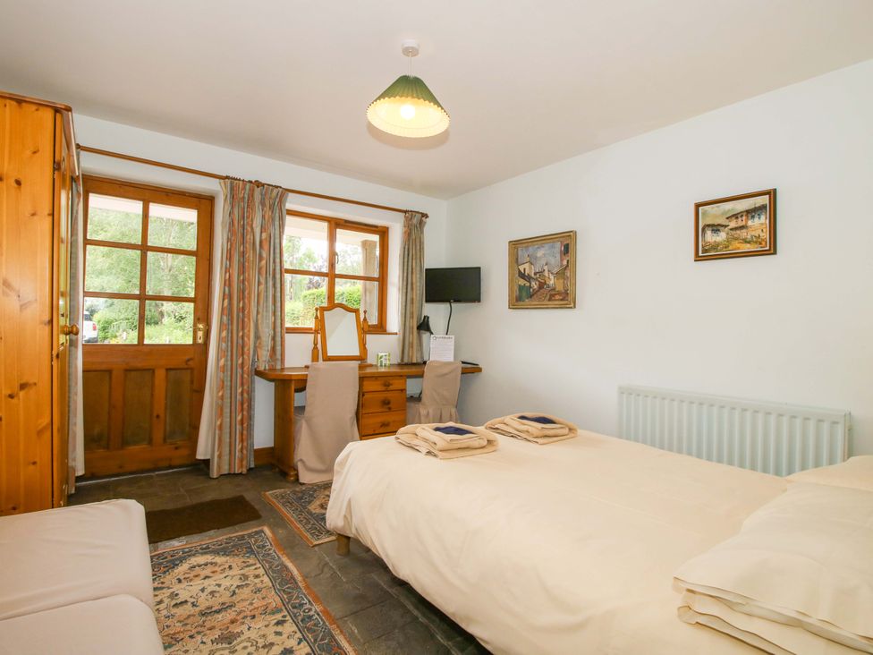 A bedroom with a bed, desk, and window at Apartment 2 in Lydbury North