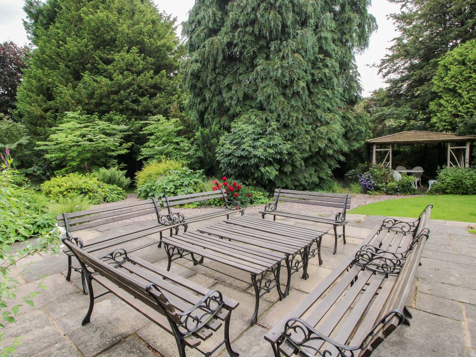 A garden with benches and a table at Apartment 2 in Lydbury North