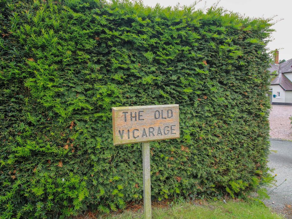 A sign that reads The Old Vicarage next to a hedge at The Old Vicarage in Lydbury North