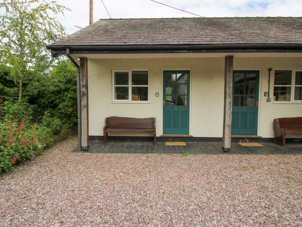 An outdoor entrance with benches and doors at Apartment 4 in Lydbury North