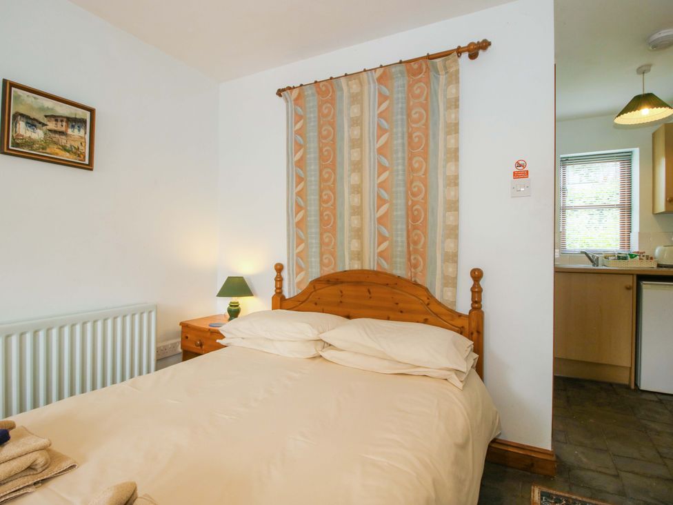 A bedroom with bed and a kitchen area at Apartment 4 in Lydbury North