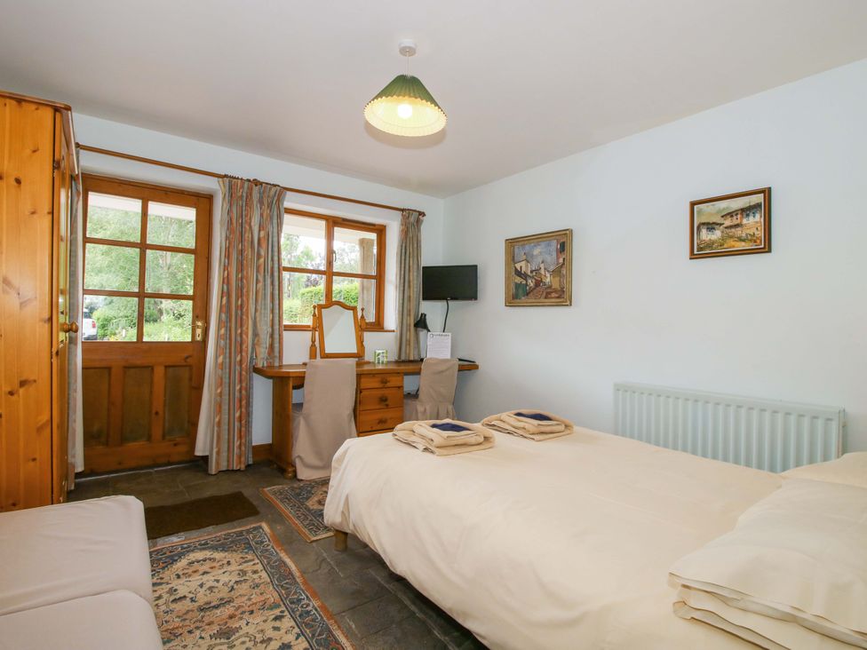 A bedroom with a bed, desk, and window at Apartment 4 in Lydbury North