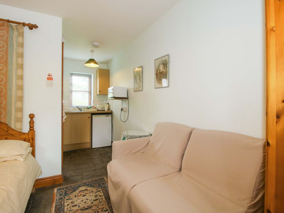 A studio apartment with a sofa and kitchenette at Apartment 4 in Lydbury North