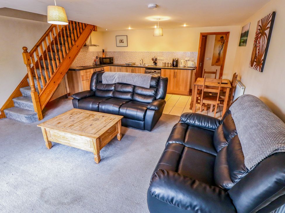 A living room with a staircase and kitchen cabinets at Holiday Cottage 1 in Skegness
