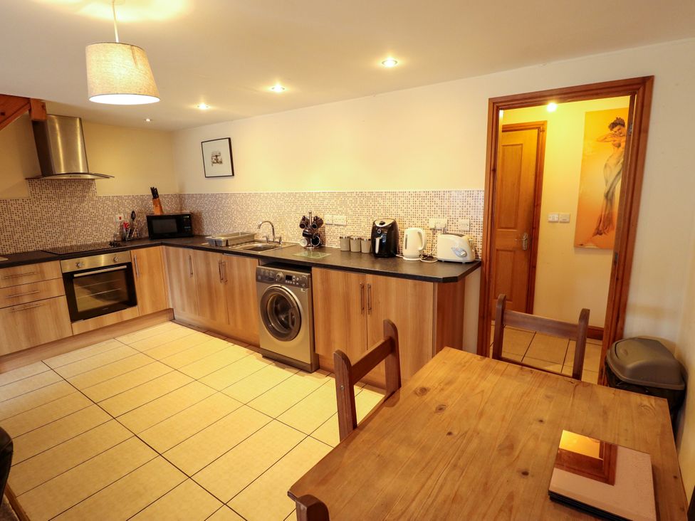 A kitchen with appliances and a dining table at Holiday Cottage 1 in Skegness