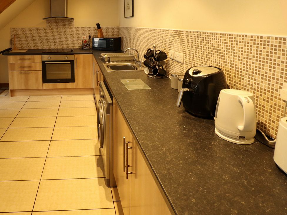 A kitchen with appliances and utensils at Holiday Cottage 1 in Skegness