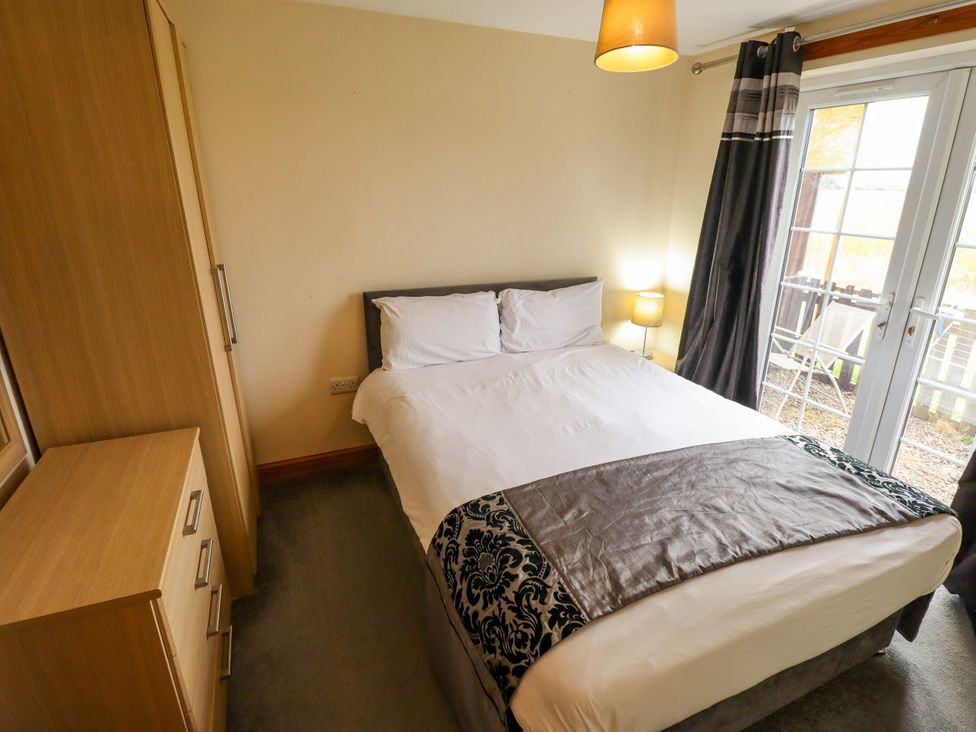 A bedroom with a bed and wardrobe at Holiday Cottage 1 in Skegness