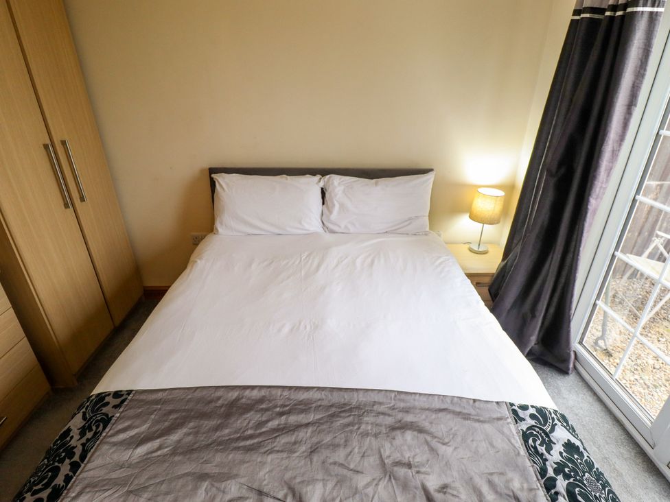 A bedroom with a bed and wardrobe at Holiday Cottage 1 in Skegness