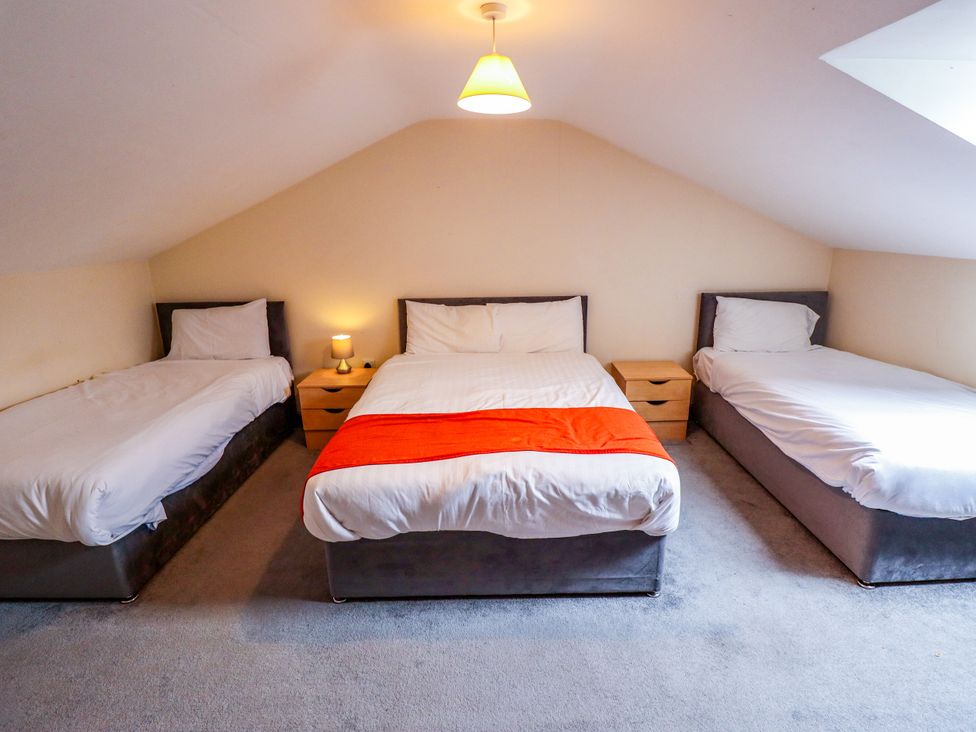 A bedroom with three beds at Holiday Cottage 1 in Skegness