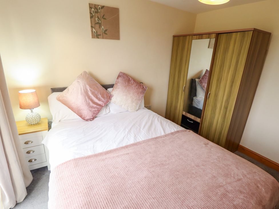 A bedroom with a bed and wardrobe at Holiday Cottage 2 in Skegness