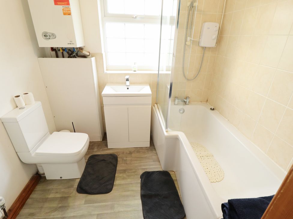 A bathroom with a toilet, sink, and bathtub at Holiday Cottage 2 in Skegness
