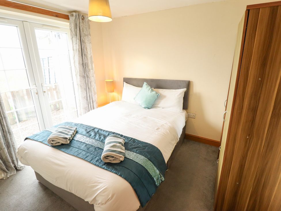 A bedroom with a bed and wardrobe at Holiday Cottage 3 in Skegness