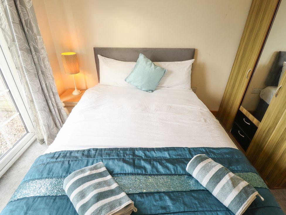 A bedroom with a bed and wardrobe at Holiday Cottage 3 Skegness