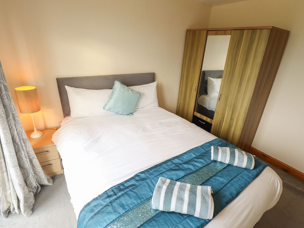 A bedroom with a bed and wardrobe at Holiday Cottage 3 in Skegness