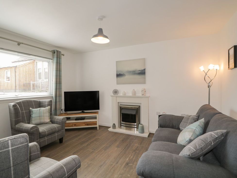 A living room with a television and seating area at The Cairn