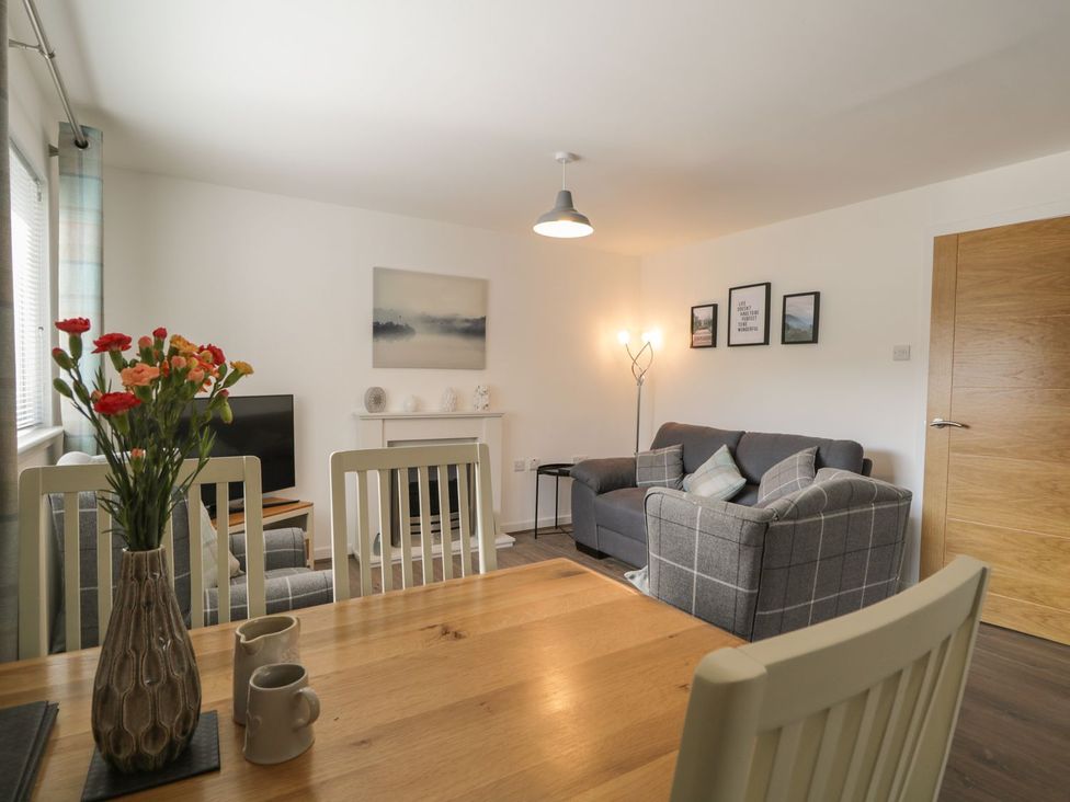 A living room with a dining table and sofa at The Cairn in 