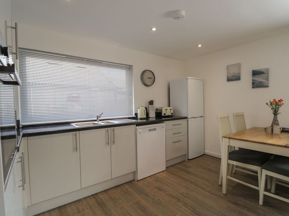 A kitchen with appliances and a dining table at The Cairn